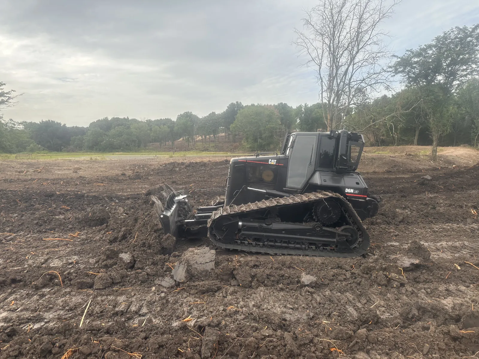 Dozer pushing dirt across an open field