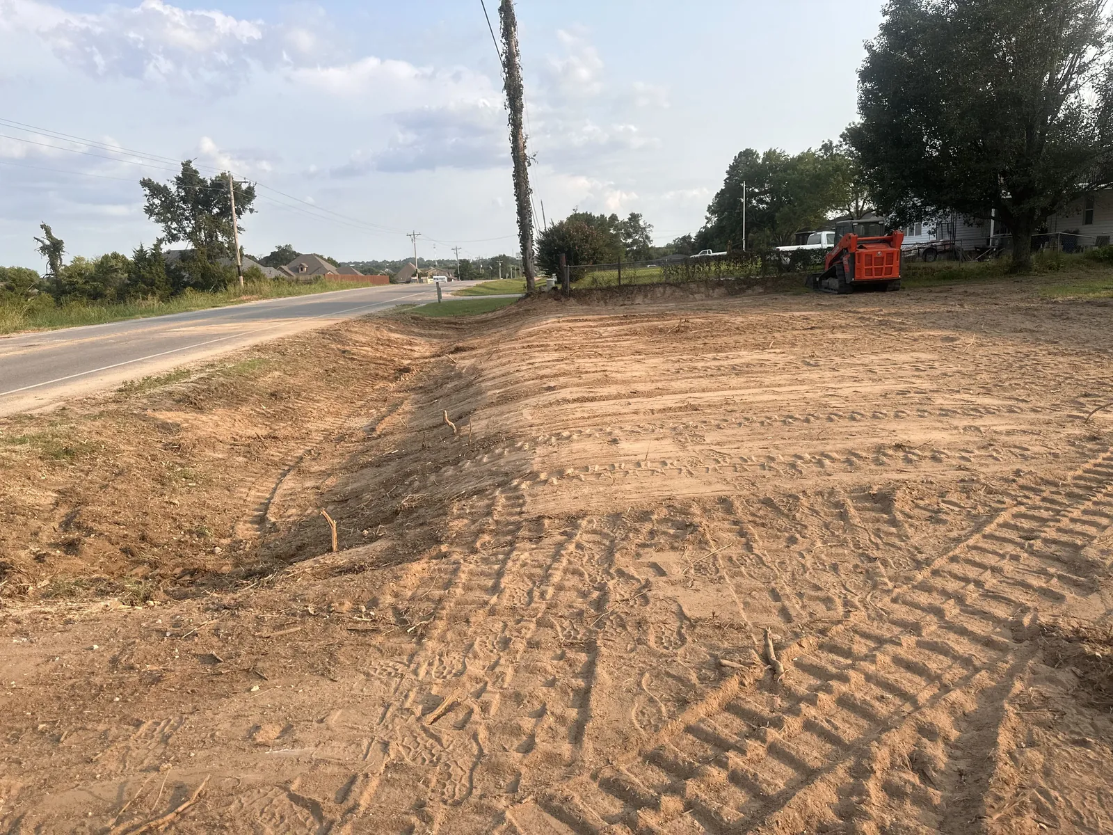Freshly graded drive shedding water on rural Oklahoma ground