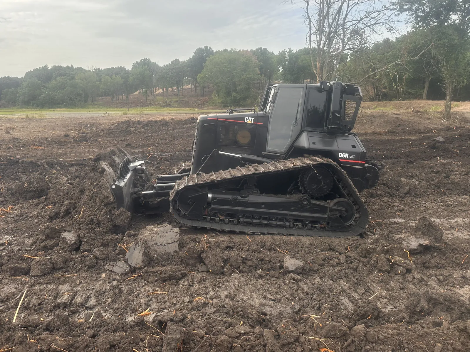 Cat D6 dozer pushing dirt across freshly cleared ground