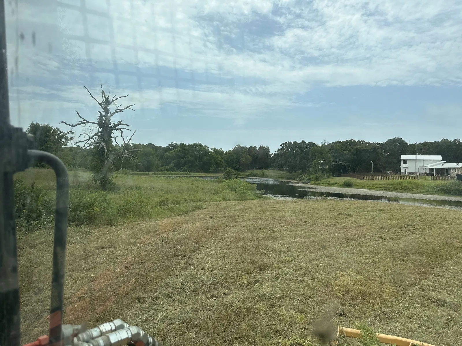 Pasture with pond water standing in the distance